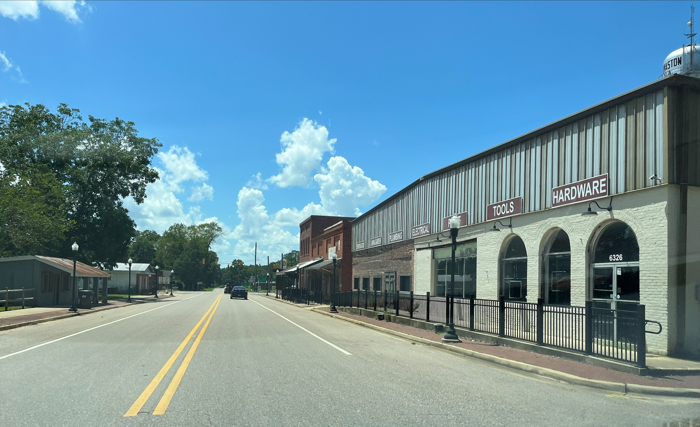 Main Street in downtown Thomaston, Alabama, under a bright blue sky.